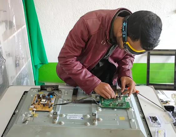 Expert TV technician diagnosing and fixing circuit board for optimal viewing experience.